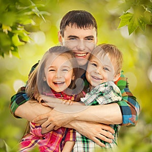 Joyful father hugging his son and daughter