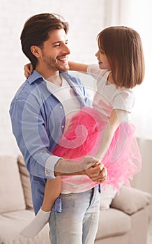 Joyful father and little princess daughter dancing waltz at home