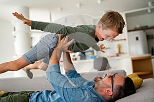 Joyful father and son having fun, spending tim at home together. Single dad concept