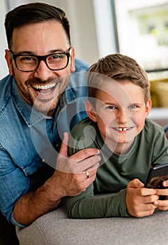 Joyful father and son having fun, spending tim at home together. Single dad concept