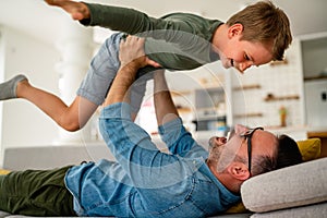 Joyful father and son having fun, spending tim at home together. Single dad concept