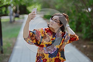 Joyful female capturing a selfie on a sunny day in the park