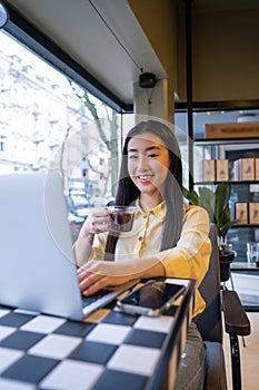 Joyful female freelancer using her laptop during the coffee break