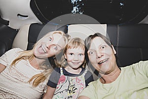 Joyful female friends go to a party in a taxi