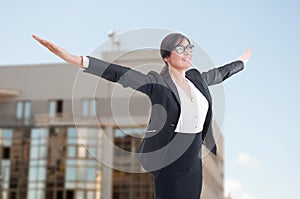 Joyful female realtor with arms outstretched