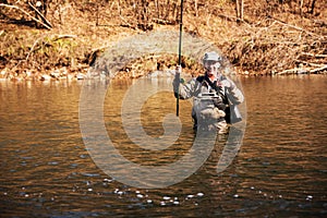 Joyful fisherman holding a grayling caught
