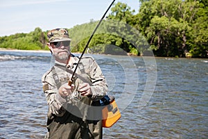 Joyful fisherman pulls caught salmon