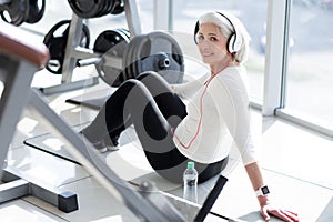 Joyful fit senior woman relaxing with music after workout.