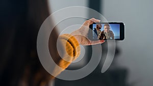 Joyful friends calling videochat on trip. Closeup girl waving smartphone screen