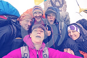 Joyful friends, hikers taking selfie while traveling in the wild