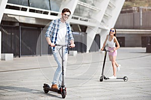 Joyful friends riding kick scooters photo