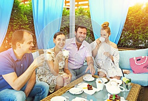 Joyful friends sitting by served table in cafe