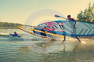 Joyful friends with SUP boards run to the water