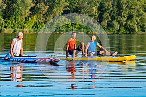 Joyful friends, a SUP surfers relax on the big river