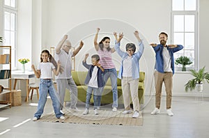 Joyful, funny, excited family having fun and dancing all together in their house or apartment