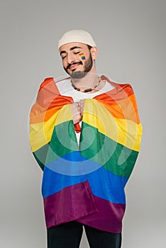 Joyful gay man holding lgbt flag