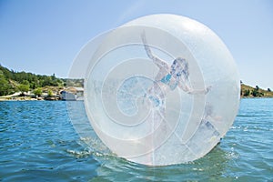 Joyful girl in a balloon floating on water.