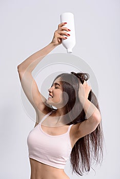 Joyful girl cleaning head with hygiene product