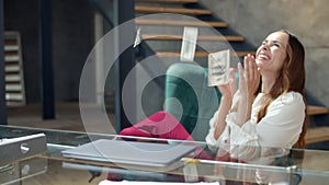 Joyful girl counting money in office. Businesswoman receiving salary in cash