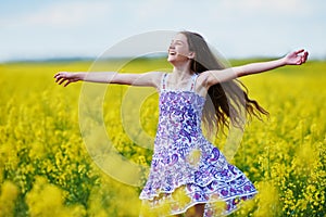 Joyful girl with flower garland at yellow seed meadow