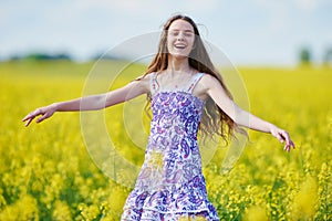 Joyful girl with flower garland at yellow seed meadow