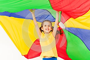 Joyful girl jumping under canopy made of parachute