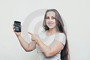 Joyful girl with long hair pokes her finger at the calculator