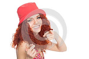 Joyful girl in a red hat pointing at the camera