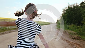 Joyful Girl Running Along Village Road by Wheat Field at Evening