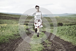 Joyful girl running on a countryside road