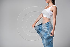 Joyful girl showing her thin figure after dieting