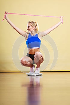 Joyful girl standing on bathroom scales