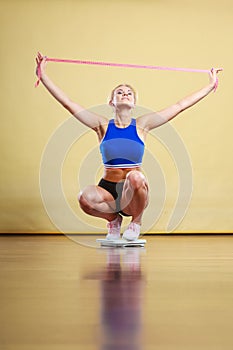 Joyful girl standing on bathroom scales