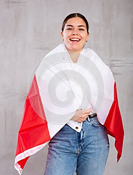 Happy girl stands with flag of Poland. Isolated on gray background photo