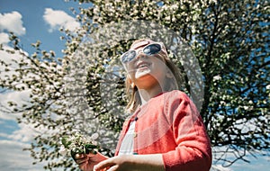 Joyful girl in sunglasses looks up to the sky