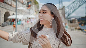 Joyful girl taking smartphone pictures at sea town closeup. Woman making selfie