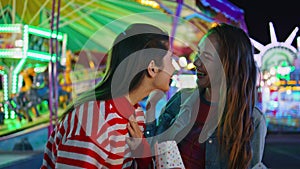 Joyful girls talking sharing secrets at luna amusement park. Happy best friends