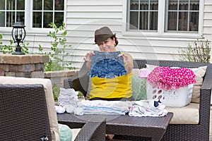 Joyful Granny folding her granddaughters clothes