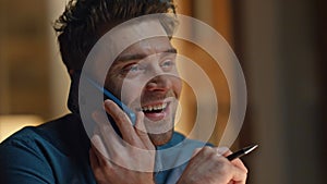 Joyful guy talking smartphone having fun at late apartment closeup. Man laughing