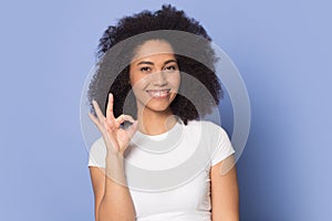 Joyful happy african american young woman showing okay gesture.