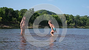 Joyful happy boy and girl play and splashed each other in the water