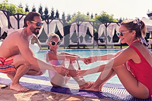 Joyful happy family clinking with champagne glasses