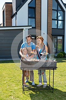 Joyful happy family grilling vegetables