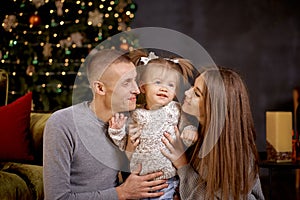 Joyful happy family with little baby girl in aesthetic cozy home interior near festive Christmas tree. Beautiful couple