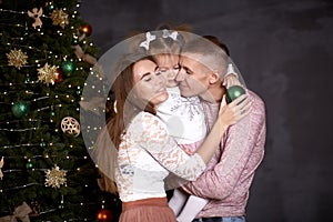 Joyful happy family with little baby girl in aesthetic cozy home interior near festive Christmas tree. Beautiful couple