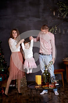 Joyful happy family with little baby girl in aesthetic cozy home interior near festive Christmas tree. Beautiful couple