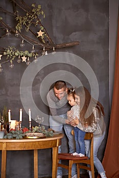 Joyful happy family with little baby girl in aesthetic cozy home interior near festive Christmas tree. Festive table