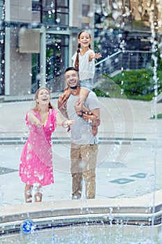 Joyful happy family looking at the water drops