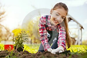 Joyful happy girl using gardening tools