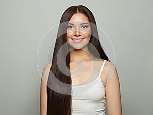 Joyful healthy female model with clean skin, make-up and perfect hairstyle against white studio wall background